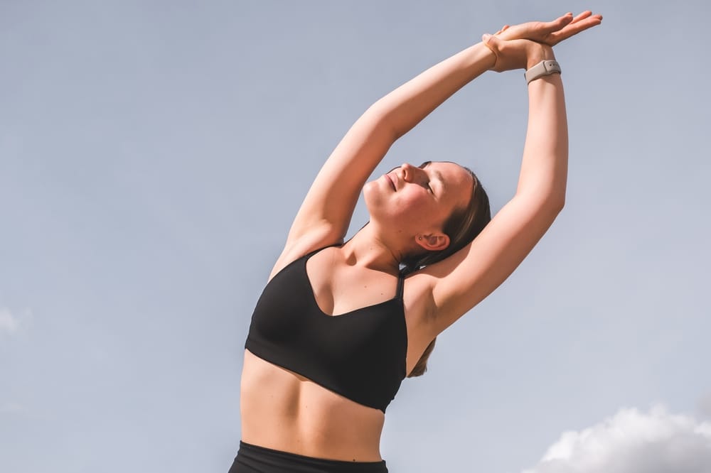 Full Body Stretch for Balance - Chiropractor in Hillview, KY A woman performs a full-body stretch outdoors, enhancing posture, flexibility, and energy for daily wellness - Chiropractor in Hillview, KY.