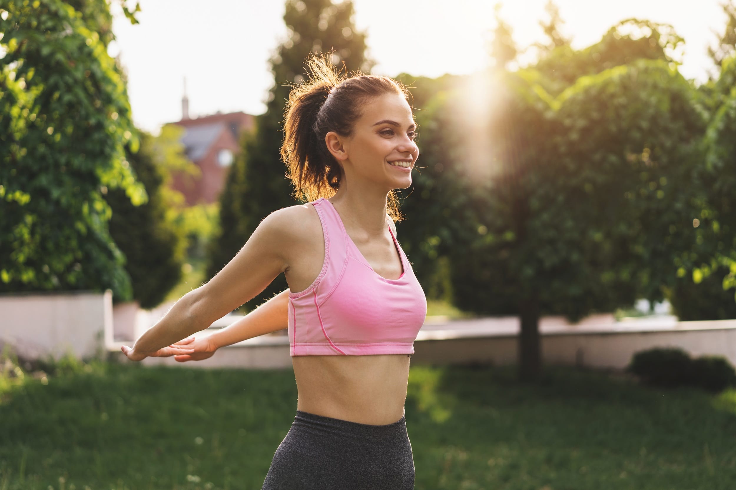 A woman enjoys outdoor stretching exercises to improve flexibility, posture, and overall wellness - Chiropractor in St Matthews.